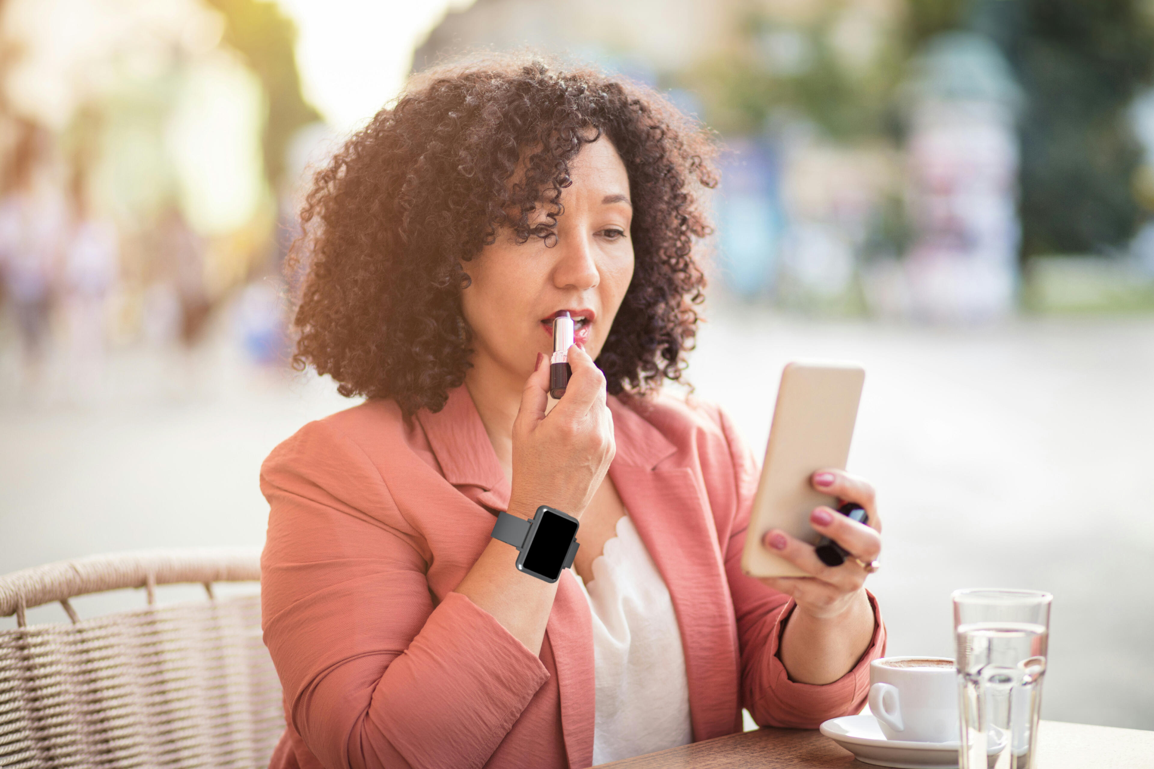 Woman applying lipstick while wearing the Cadence band. Woman applying lipstick while wearing the Cadence band.