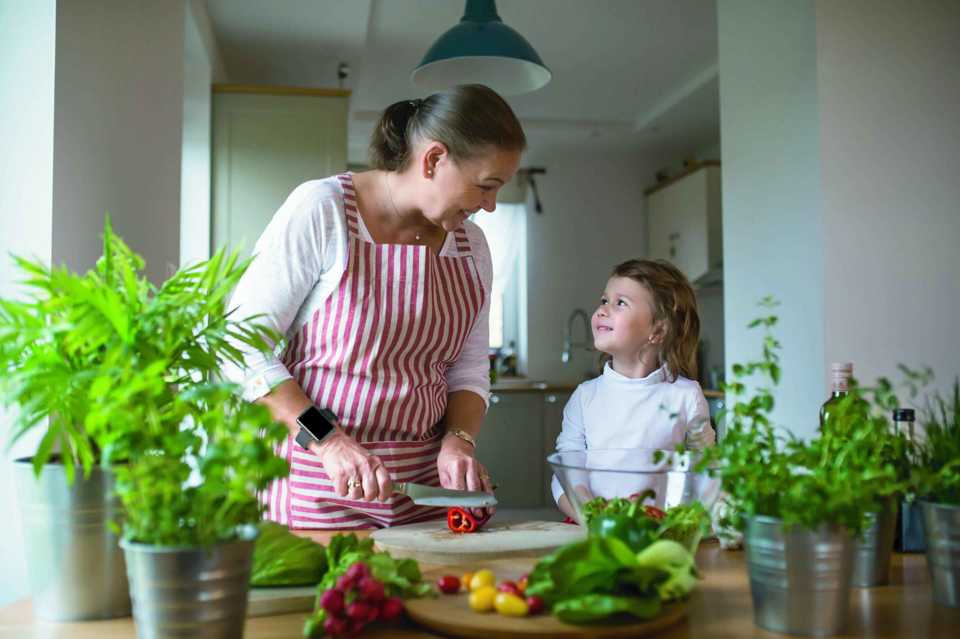 Woman cutting vegetables while wearing the Cadence band. Woman cutting vegetables while wearing the Cadence band.